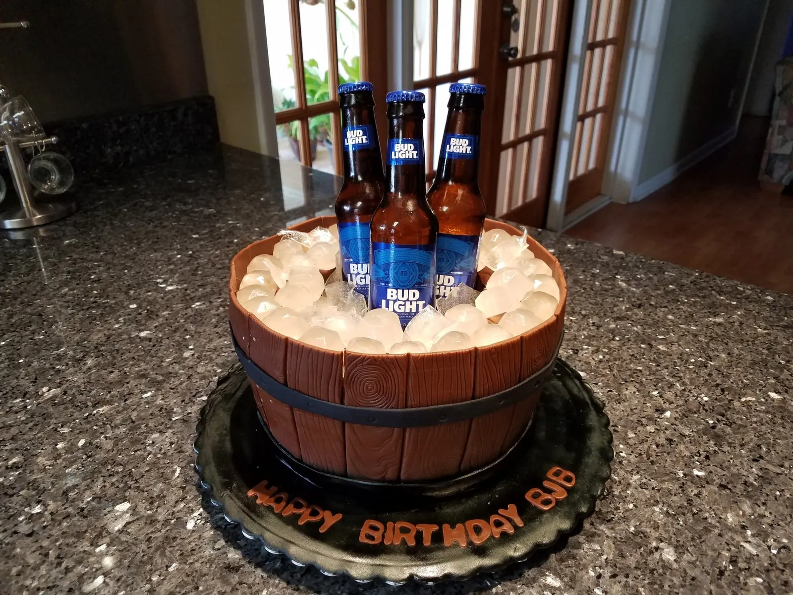 Sculpted beer bucket cake with fondant bottles and ice in a wooden barrel