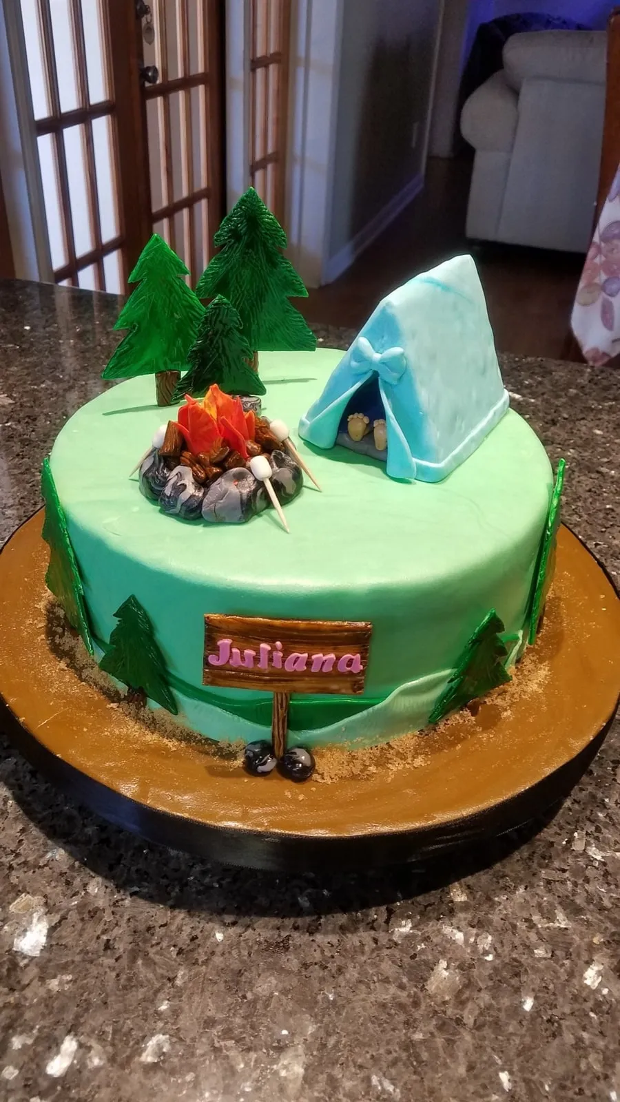 Camping themed cake with a fondant tent, campfire, pine trees and mountains