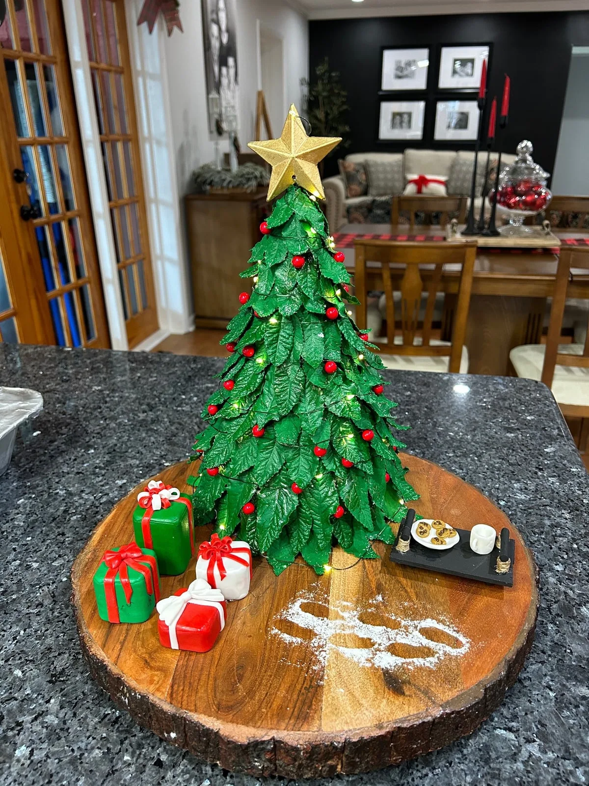 Sculpted Christmas tree cake with piped pine branches, ornaments and fondant gifts