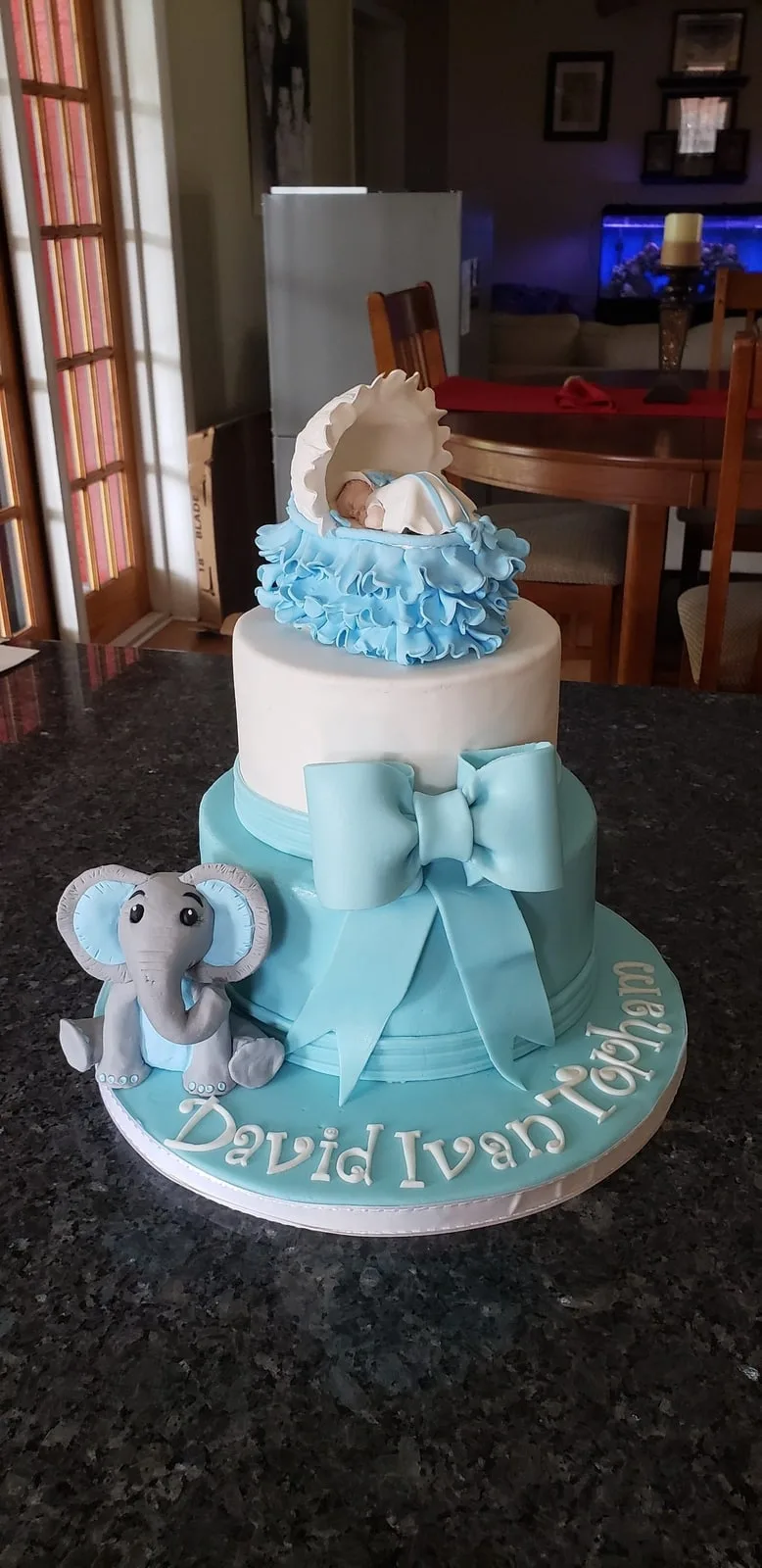 Blue and white baby shower cake with a fondant bow and hand modelled elephant