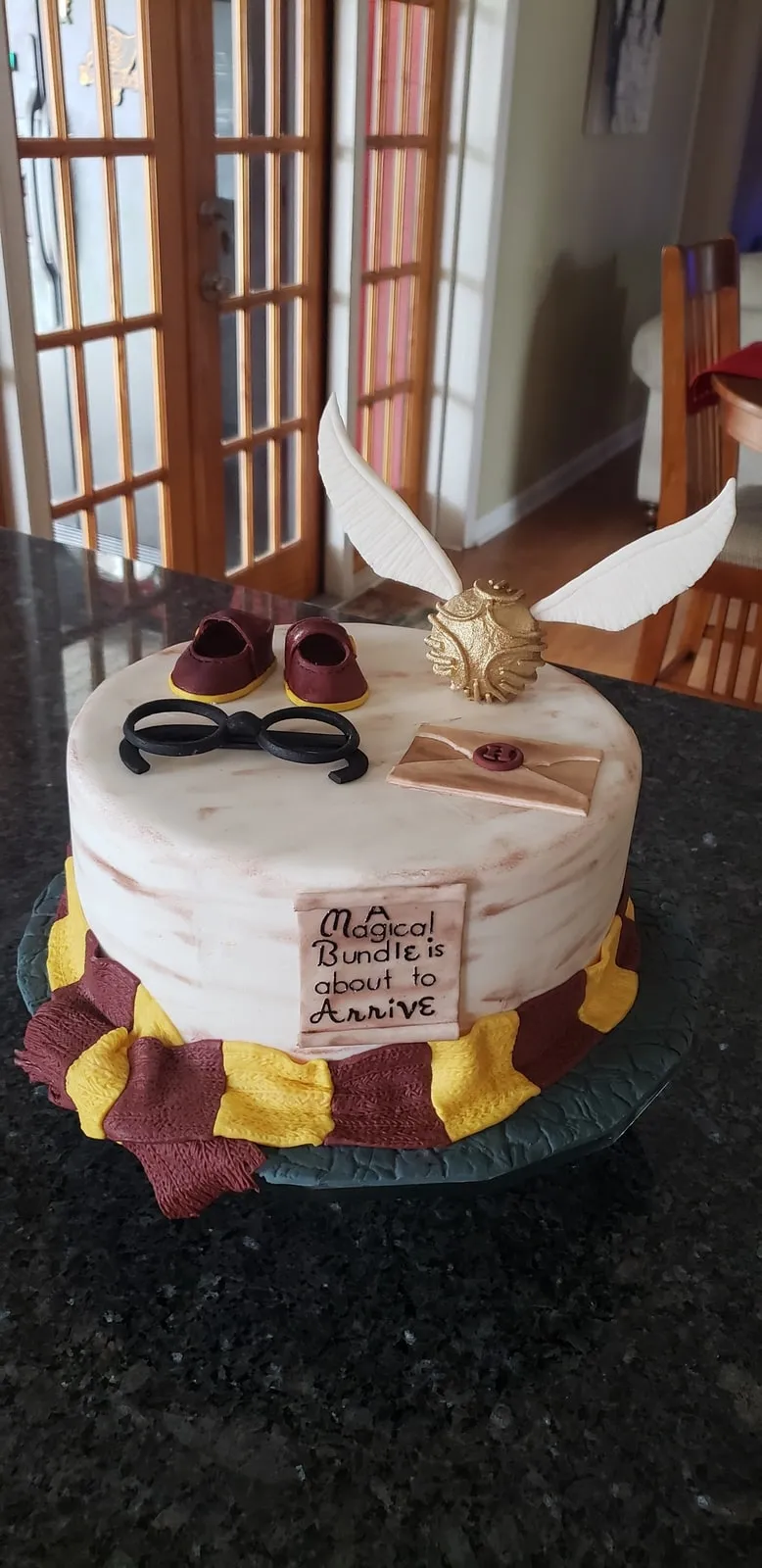 Harry Potter tiered cake with a golden snitch, wand and round glasses