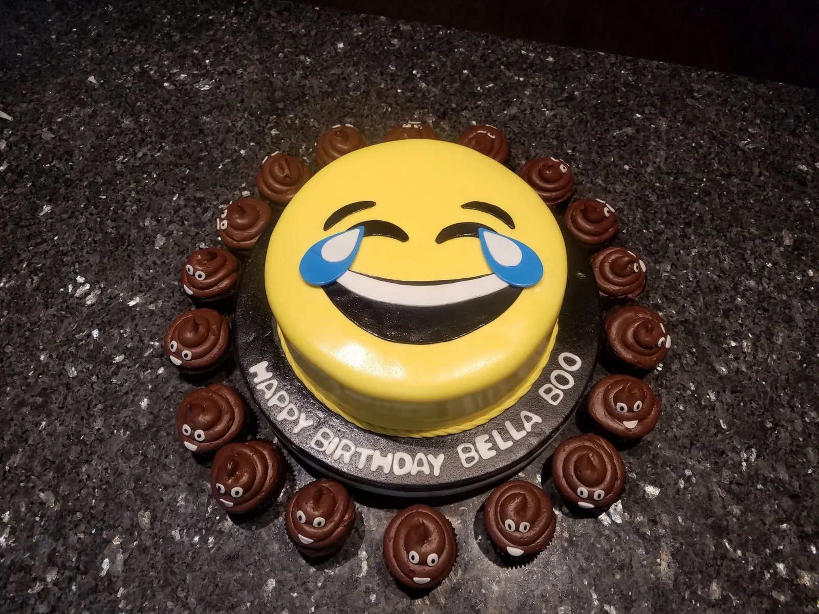 Laughing emoji birthday cake ringed with chocolate poop emoji cupcakes