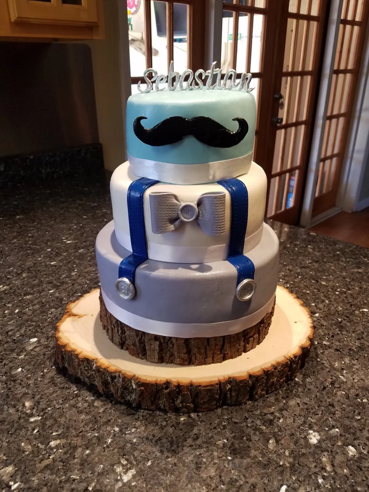 Little man baby shower cake in grey and blue with a fondant bow tie and moustache