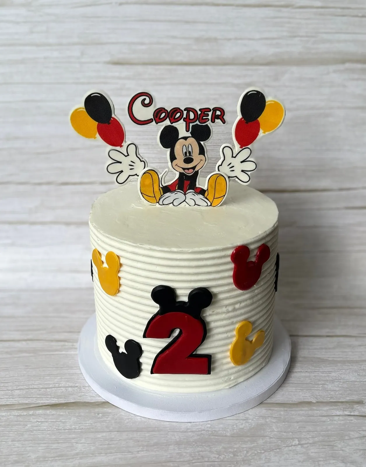 Mickey Mouse second birthday cake in red, black and yellow with balloon topper