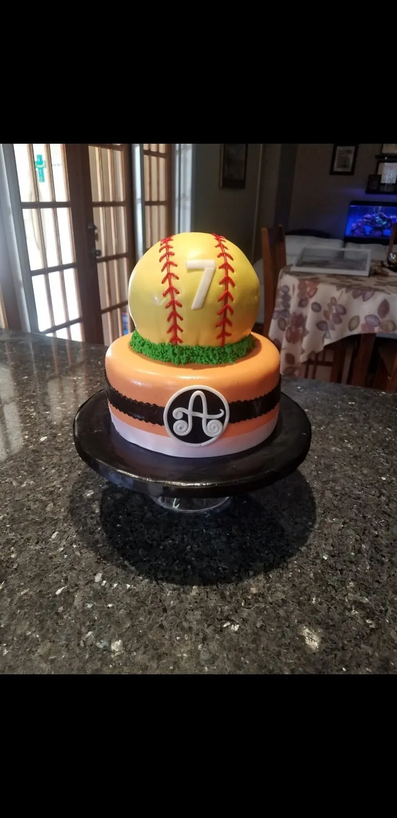 Softball themed tiered birthday cake with a sculpted ball topper