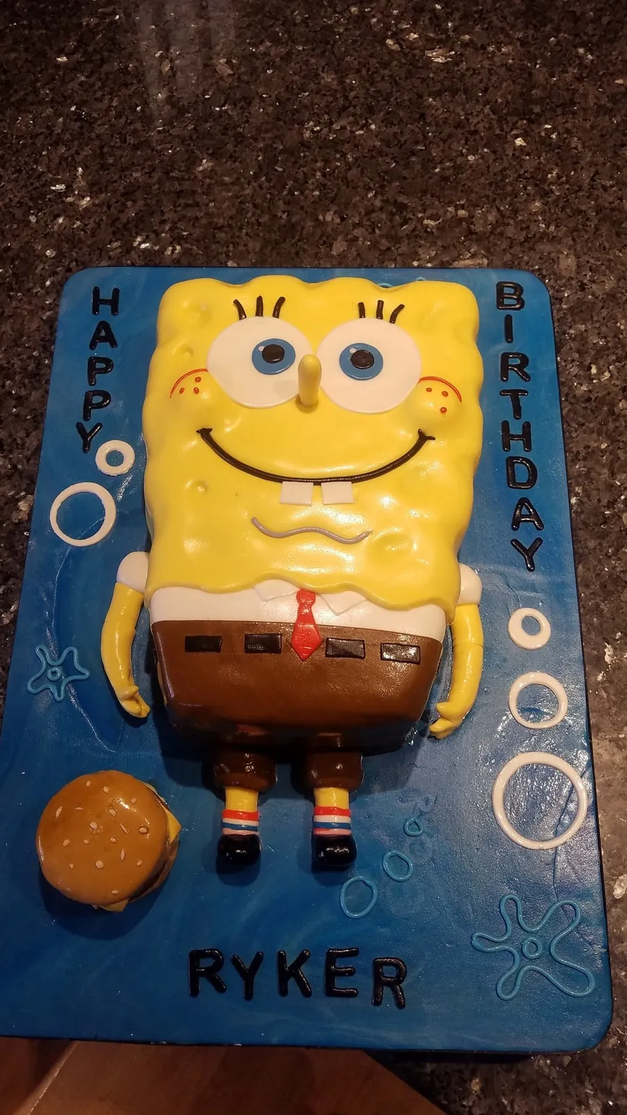 Sculpted SpongeBob birthday cake standing on a blue underwater board